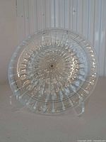 Front view of clear glass charger showing radial design