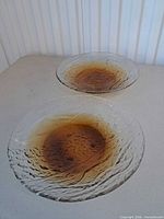 Two textured glass bowls with amber centers on tabletop