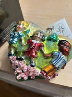 Front view of heart ornament with three children and roses