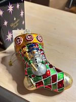 Front view of Christopher Radko stocking snowman ornament with box visible