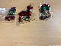 Three individually bagged ornaments: reindeer and two stockings