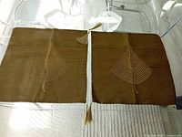 Pair of brown-gold Thai silk pillow covers with leaf motif and tassels displayed flat