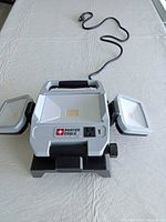 Front view showing three LED panels, outlet, USB, and cord