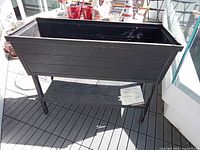 Front view showing full planter on legs and shelf