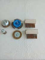 All four drill wire brushes and two paver brushes displayed on surface