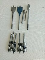 Group shot showing auger bits, two spade bits, two pilot bits, and 6" extension