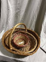Nested view of three wicker baskets, showing sizes and handle