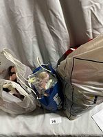 Three plastic shopping bags containing assorted Beanie Babies