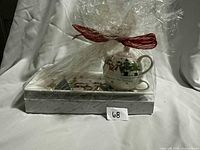 Teapot and tray wrapped together in cellophane with red ribbon