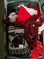 Overview of tote showing pillow, plush Santa, tinsel garland, bow and other red fabric item