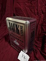 Left side view of Jack Daniel’s tin showing graphics and depth