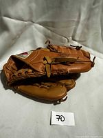 Full view of tan youth baseball glove, leather laces visible