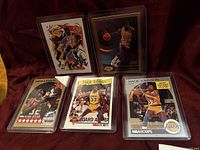 Front view of five Magic Johnson cards in top loaders