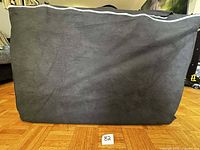 Black fabric carrying bag zipped closed, upright view