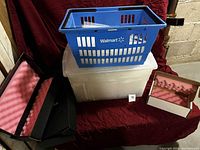 Overview of lot: three foam-lined boxes, bubble pouches in blue basket, clear storage tote