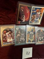 Front view of six of the Patrick Ewing cards in top loaders