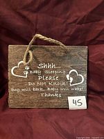 Front of wooden door sign showing printed message and hanger