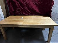 Full view of rectangular tan wood coffee table front and top