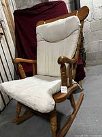 Front angled view of rocking chair showing cushions and wood frame