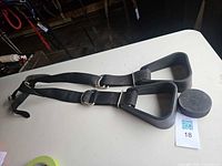 Pair of black exercise handles with adjustable straps and QR tag visible