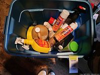 Top view of tote containing assorted spray bottles and aerosols