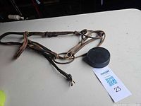 Dark brown leather bridle with reins laid on table