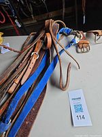 Assorted leather straps and blue lead rope laid out on table