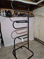 Full view of black metal vertical saddle rack showing base and arms