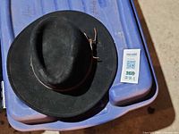 Top and side view of black wool felt rancher hat showing overall shape and leather band