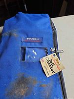 Front view of blue blanket with tag and zipper