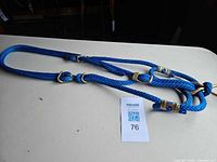 Full view of blue nylon rope halter laid flat showing overall length and hardware