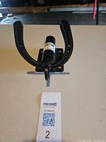 Front view of black horseshoe gate latch on table