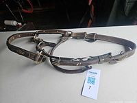 Full view of brown leather bridle headstall laid flat on table