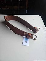 Full view of leather breast strap coiled showing overall condition and hardware