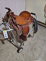 Full side view of saddle on stand with stirrups and girth visible
