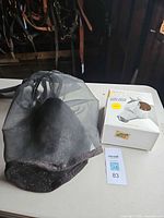 Loose black mesh fly mask next to boxed mask