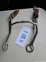 Full view of stainless steel curb bit with leather straps and center roller