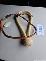 Full view of rawhide bosal with attached leather headstall laid on table