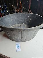 Overall view of black feed tub showing shape and size