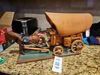 full view of covered wagon model with horse on countertop