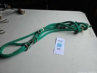 Full view of green rope halter laid flat showing overall size and hardware