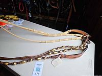 Full view of rawhide mecate reins and beaded leather reins laid on table
