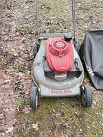 Front view of mower showing engine cover, deck and wheels