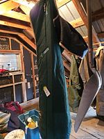 Full length view of green horse blanket hanging, tan trim visible