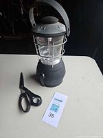 Lantern and scissors side by side on table