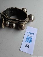 Full view of leather strap with five bells and buckle