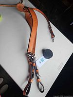 Full view of leather breast strap laid out showing center panel, attachment straps and hardware