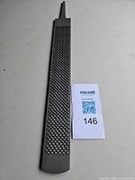 Full view of long steel rasp showing tang and rasp teeth