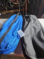 Blue and black canvas gear bags side by side on table