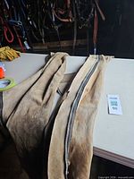 Top view of both suede chaps laid out showing zippers and overall wear